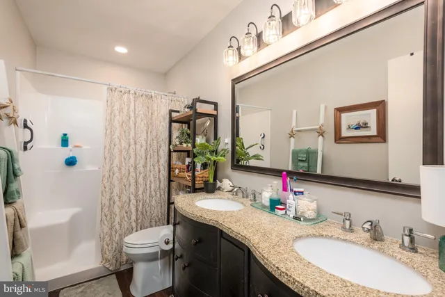 a bathroom with a granite countertop sink toilet and shower