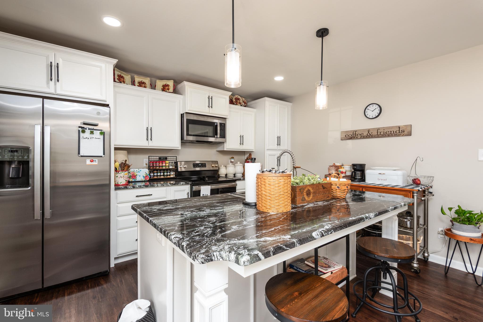 505 Maryland Avenue Ridgely, MD 21660 - Photo 8 of 23 a kitchen with kitchen island granite countertop a sink a center island stainless steel appliances and cabinets