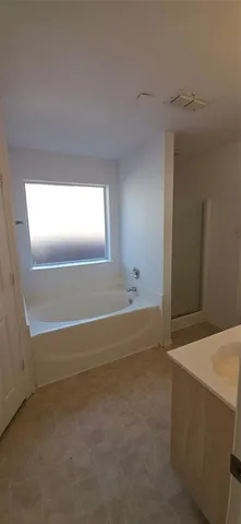 a bathroom with a tub sink and mirror