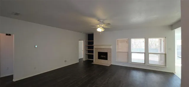 a view of an empty room with a fireplace and a window