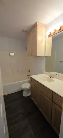 an empty room with chandelier fan and windows