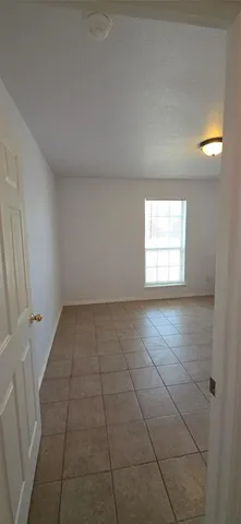 a view of empty room with chandelier fan and window
