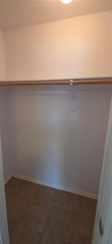 a view of an empty room with chandelier fan