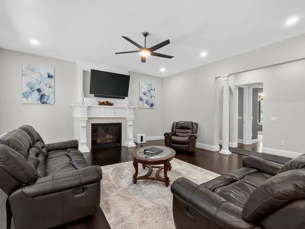 a living room with furniture a flat screen tv and a fireplace