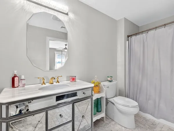 a bathroom with a sink a toilet and a mirror