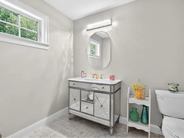 a bathroom with a toilet a sink and mirror