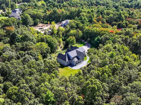 a view of a house with a lush green forest