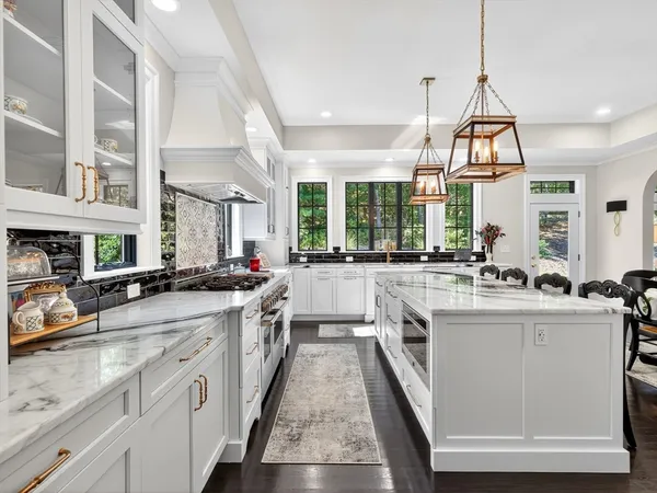 a large kitchen with stainless steel appliances granite countertop lots of counter space and a sink