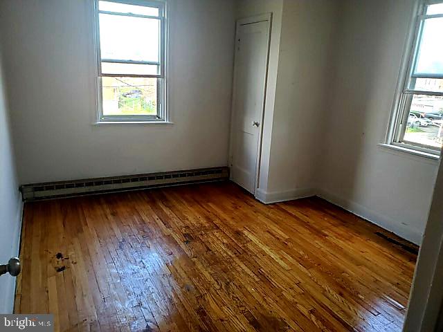 2939 Cornwall Road Dundalk, MD 21222 - Photo 5 of 6 an empty room with wooden floor and windows