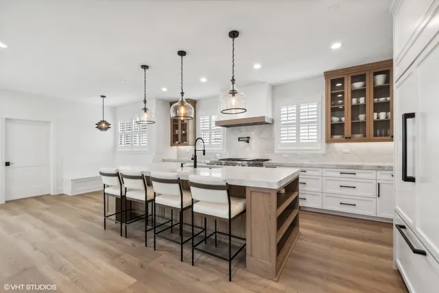 a kitchen with kitchen island granite countertop a table chairs sink and cabinets