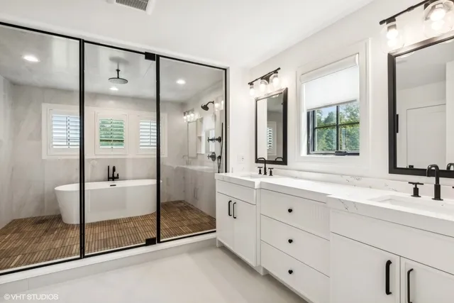 a bathroom with a double vanity sink mirror and shower