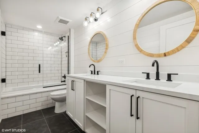 a bathroom with a toilet a sink a mirror and bathtub