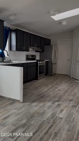 a kitchen with stainless steel appliances wooden cabinets and a counter top space