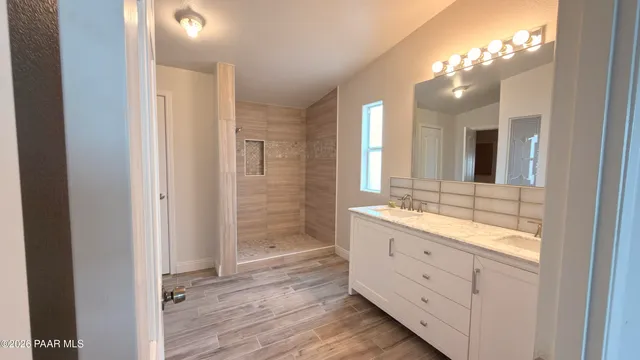 a bathroom with a double vanity sink and mirror with shower