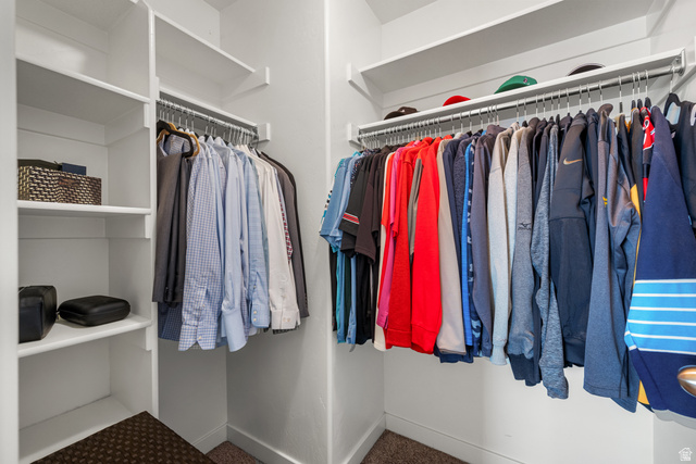 955 Delorean Lane Midvale, UT 84047 - Photo 22 of 47 Walk-in closet featuring white built-in shelving, multiple hanging rods, and carpet flooring
