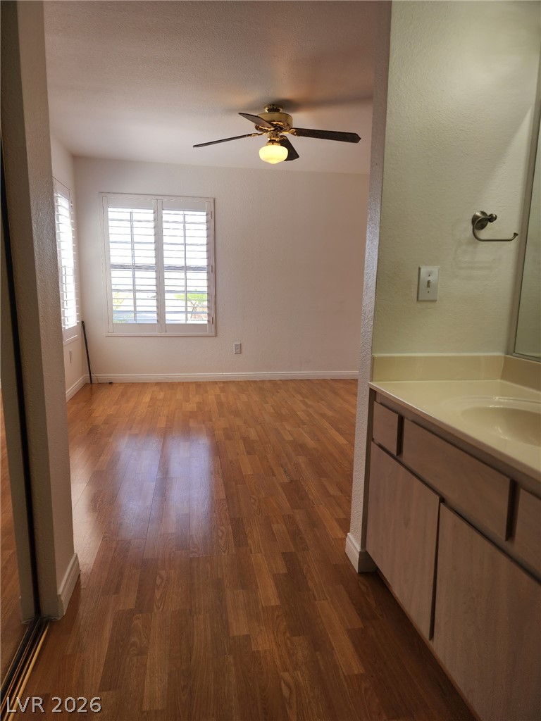 231 West Horizon Ridge Parkway, Unit 1127 Henderson, NV 89012 - Photo 22 of 39 Laminate flooring extends into a spacious bedroom, offering ample light through plantation-shuttered windows.