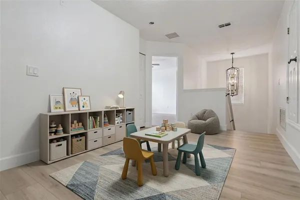 a spacious bedroom with a bed couches chair and wall paintings