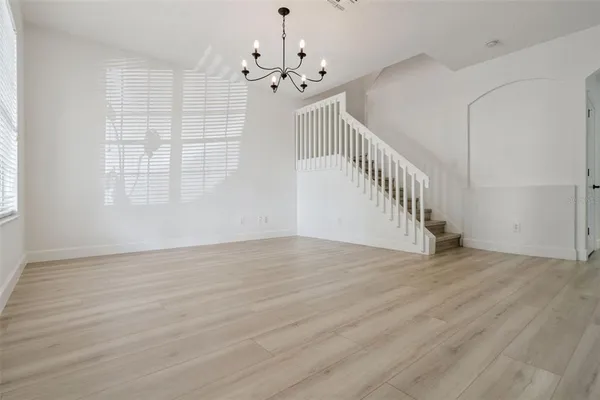 a view of a dining room with furniture a chandelier and wooden floor