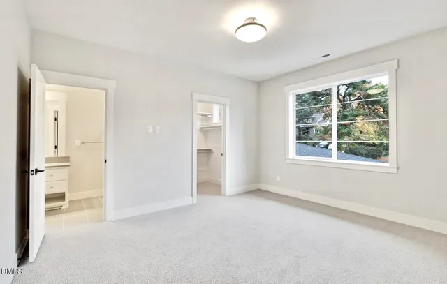 an empty room with windows and closet