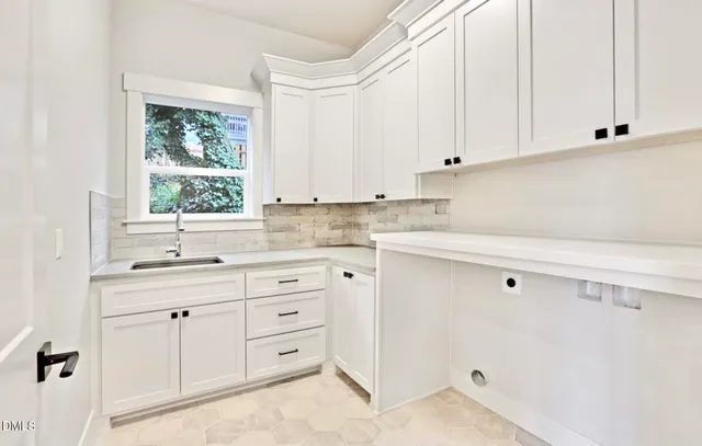 a kitchen with granite countertop white cabinets and window