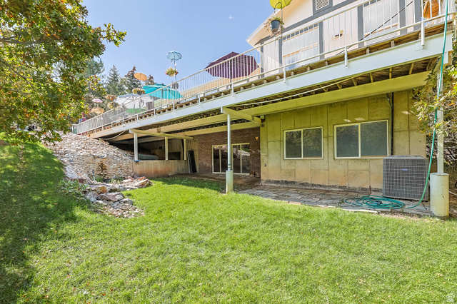 569 Elk Meadow Loop Tooele, UT 84074 - Photo 4 of 56 Rear view of property featuring a lawn, a patio, and board and batten siding