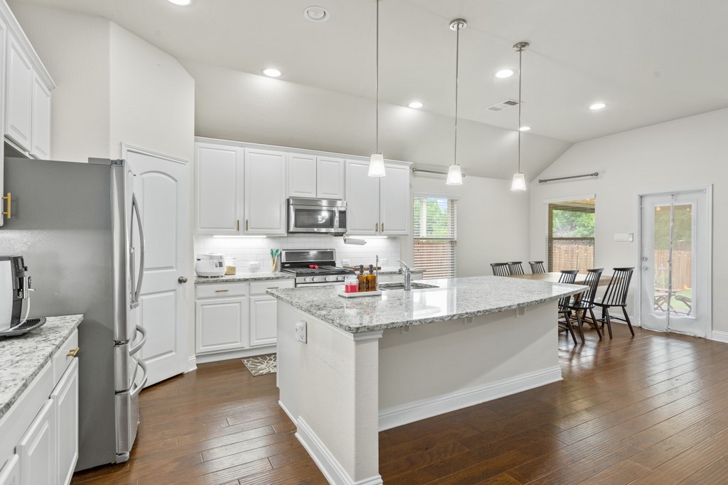 1916 Elaina Loop Leander, TX 78641 - Photo 10 of 23 a kitchen with white cabinets and stainless steel appliances