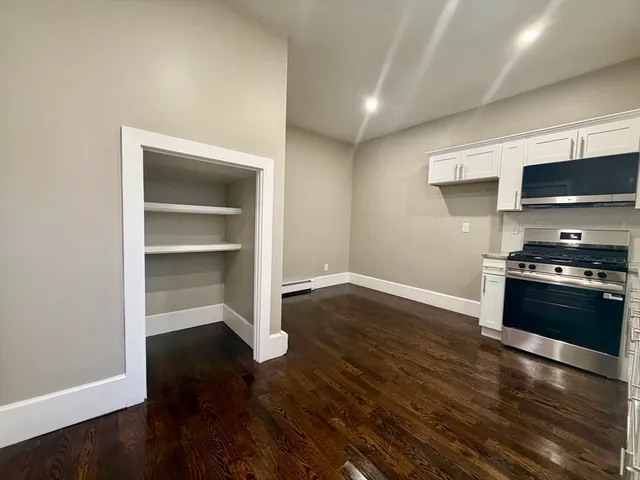 a kitchen with a refrigerator and a stove top oven