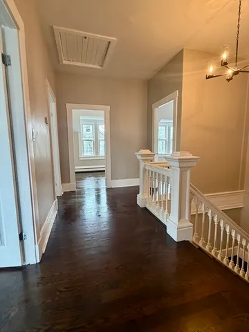 a view of a room with wooden floor windows and a fireplace