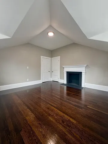 an empty room with wooden floor and fireplace