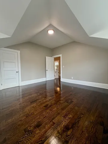 an empty room with wooden floor and white walls