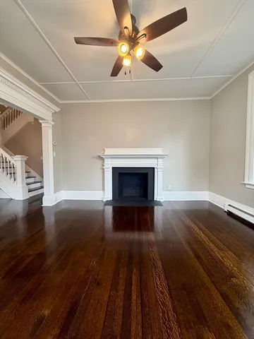 a view of empty room with wooden floor and fireplace