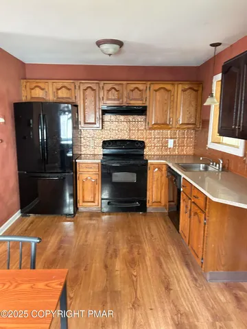 a kitchen with stainless steel appliances granite countertop a refrigerator and a stove