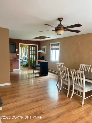 a dining room with furniture a chandelier and wooden floor