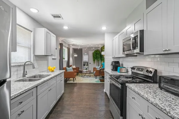 a kitchen with stainless steel appliances granite countertop a sink stove and cabinets