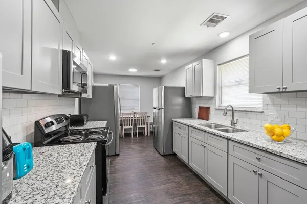 a kitchen with stainless steel appliances granite countertop a sink stove and refrigerator