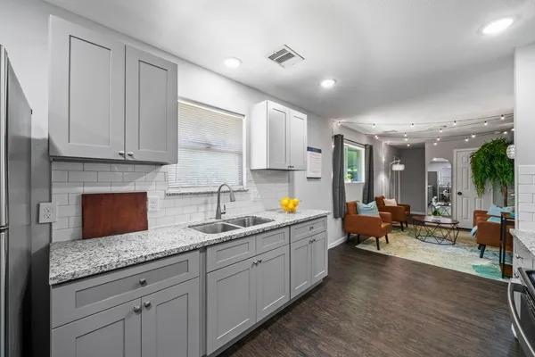a kitchen with granite countertop a sink and white cabinets