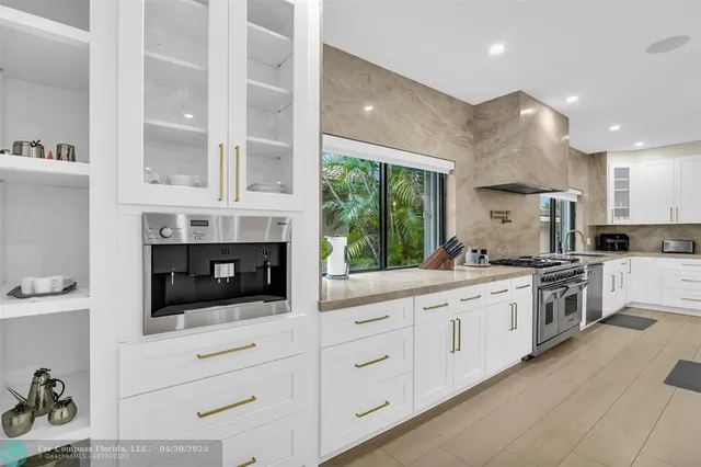 a view of kitchen with kitchen island stainless steel appliances a sink and stove