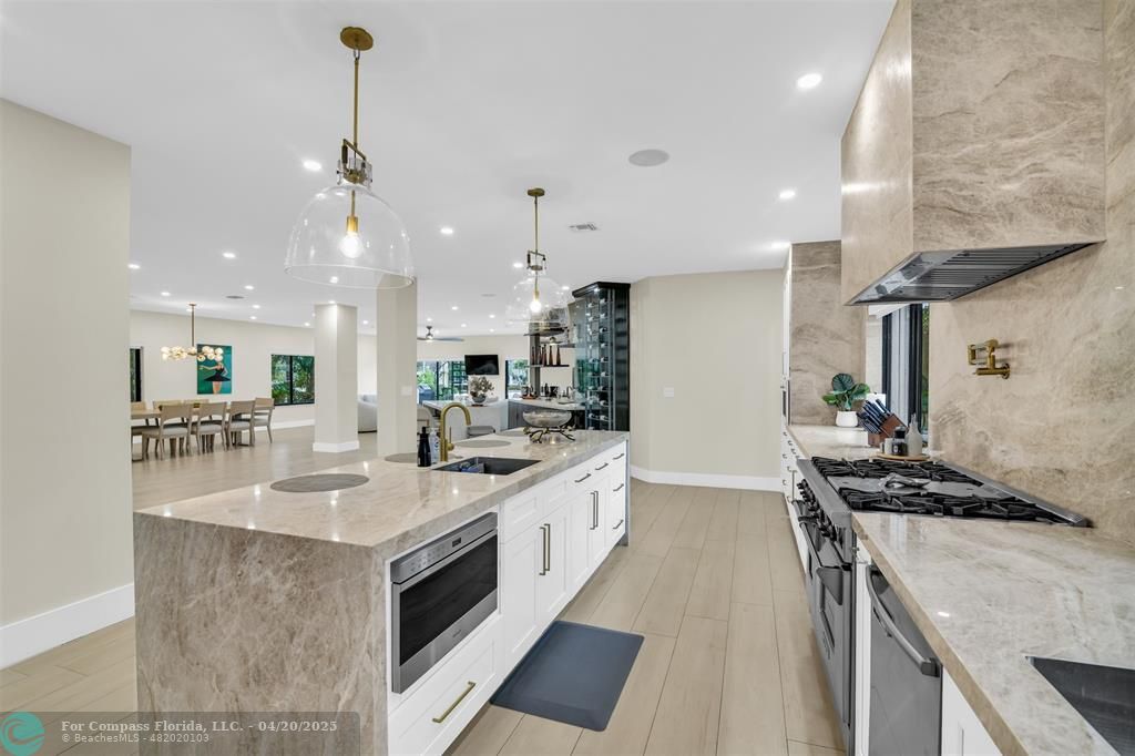 319 South Riverside Drive Pompano Beach, FL 33062 - Photo 18 of 98 a kitchen with stainless steel appliances a sink a stove a chimney a sink and cabinets