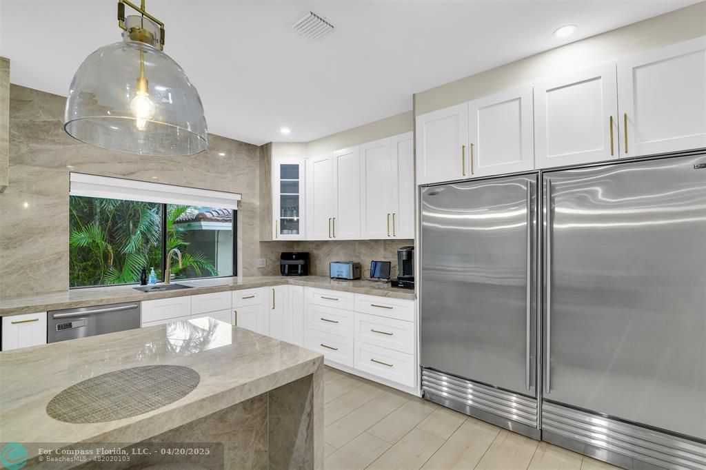 319 South Riverside Drive Pompano Beach, FL 33062 - Photo 19 of 98 a kitchen with stainless steel appliances granite countertop a sink a stove and refrigerator