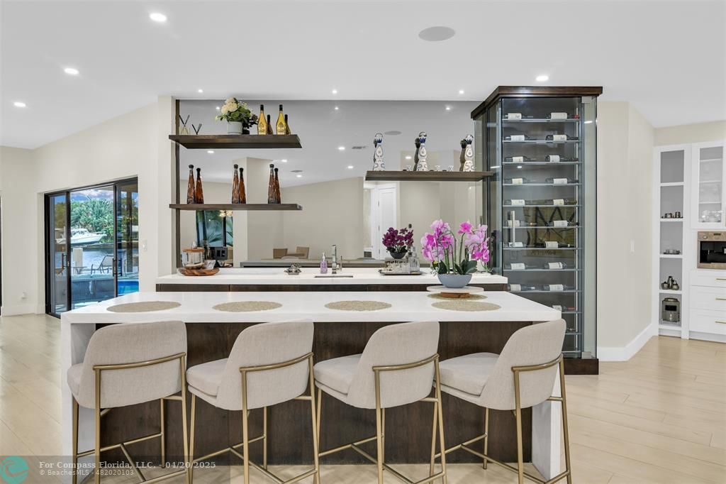 319 South Riverside Drive Pompano Beach, FL 33062 - Photo 29 of 98 a kitchen with stainless steel appliances kitchen island granite countertop a dining table and chairs in it