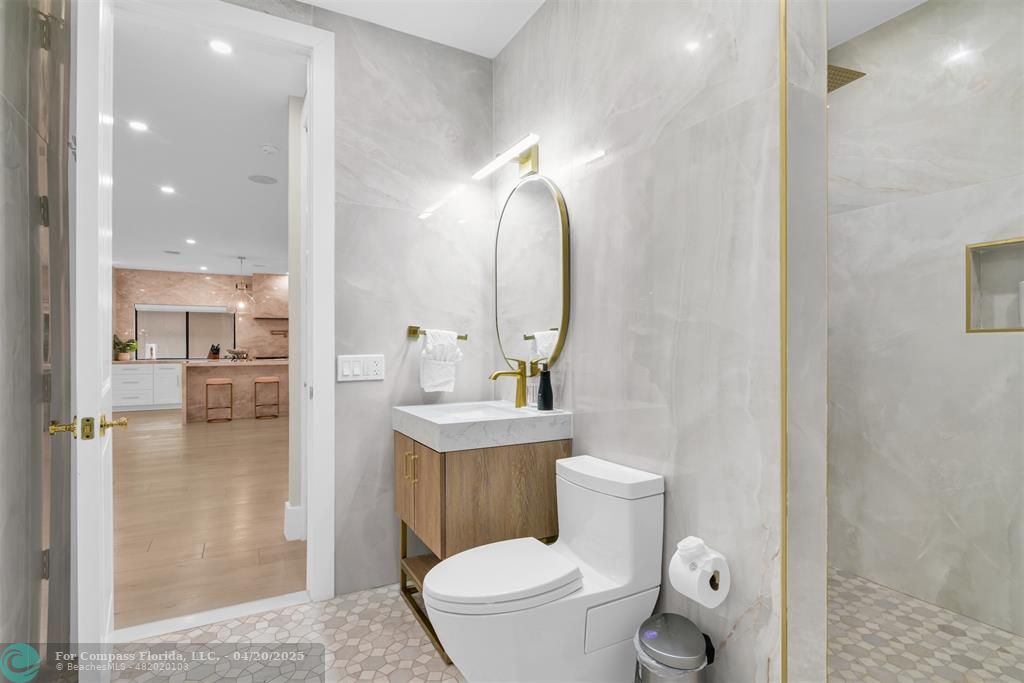 319 South Riverside Drive Pompano Beach, FL 33062 - Photo 54 of 98 a bathroom with a toilet a sink and mirror