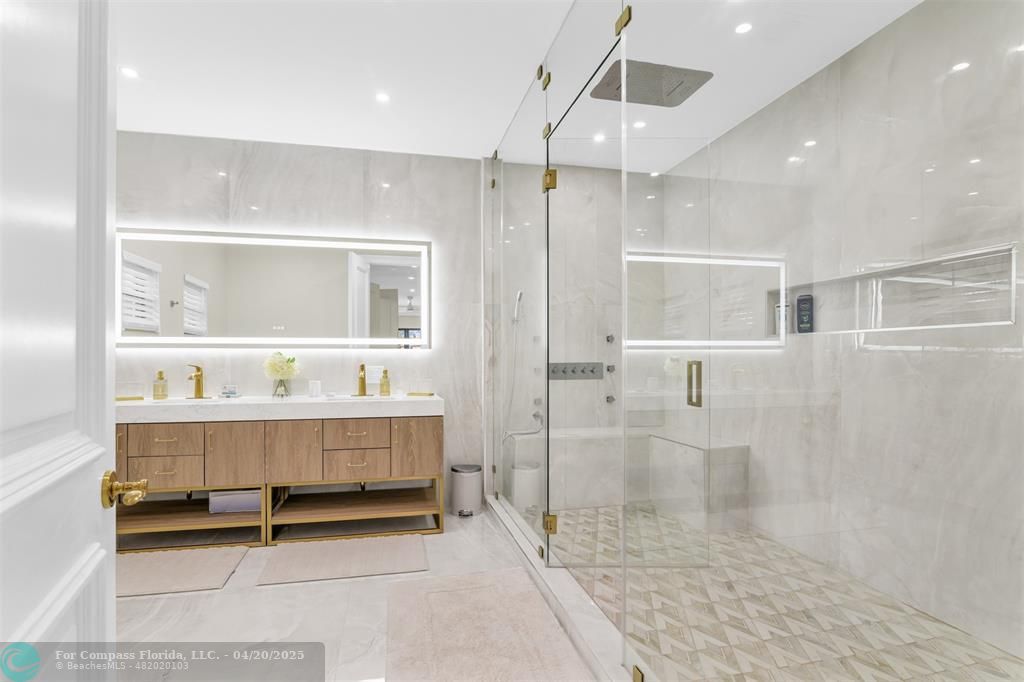 319 South Riverside Drive Pompano Beach, FL 33062 - Photo 72 of 98 a bathroom with a glass shower door and a sink