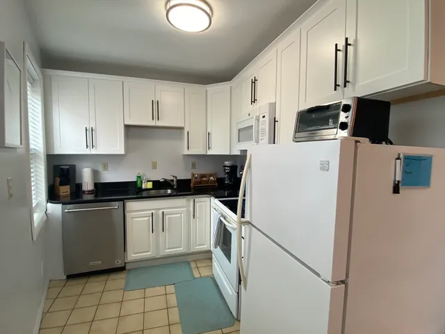 a kitchen with a refrigerator a sink and cabinets