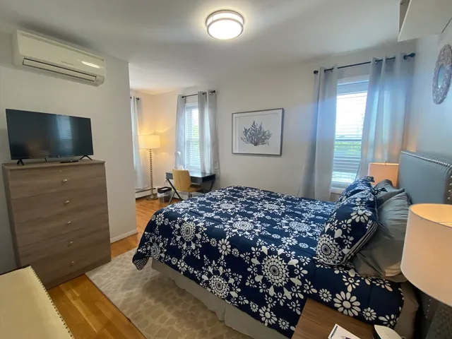 a bedroom with a bed and flat screen tv