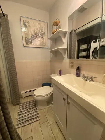 a bathroom with a toilet sink and mirror