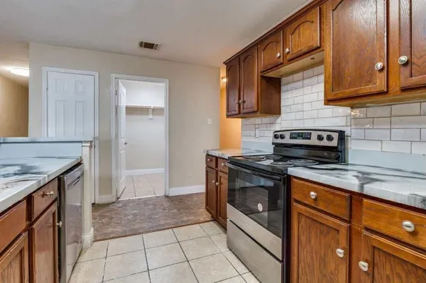 a kitchen with stainless steel appliances granite countertop a stove a sink and a microwave