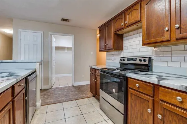 a kitchen with stainless steel appliances granite countertop a stove a sink and a microwave