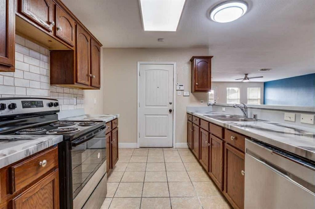 2118 Augusta Street Lancaster, TX 75146 - Photo 12 of 25 a kitchen with stainless steel appliances granite countertop a stove a sink and a microwave