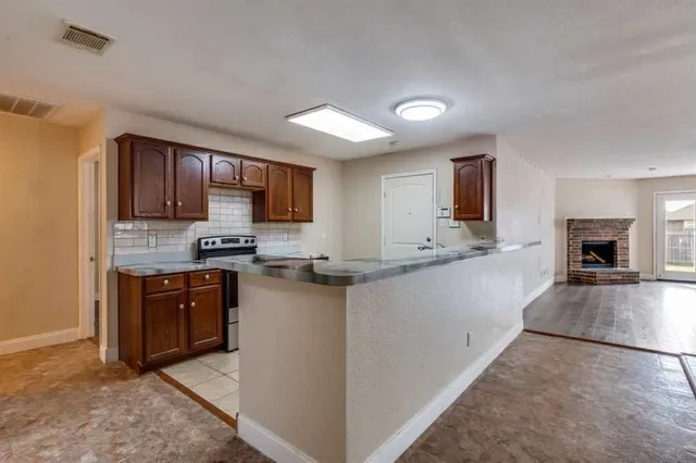 a kitchen with granite countertop a stove top oven sink and cabinets