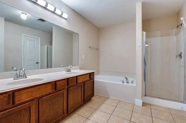 a spacious bathroom with a bathtub shower sink double and mirror